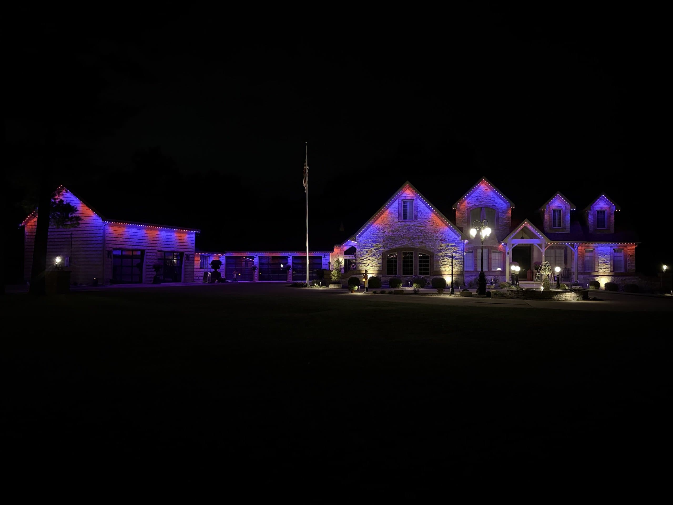 Country estate lit in red, white, and blue across every roofline
